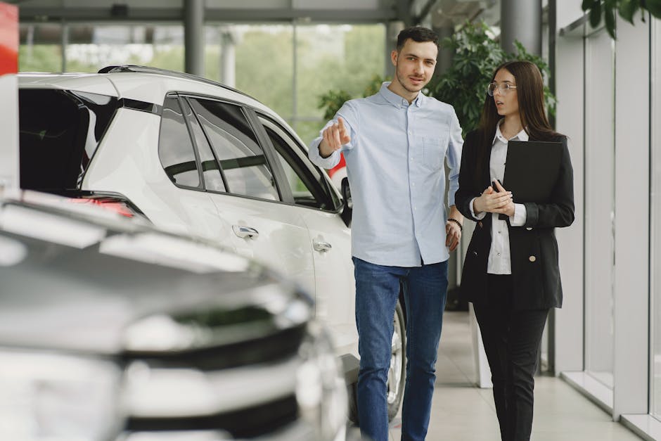 Customer and salesperson discussing a vehicle inside a modern car dealership showroom
