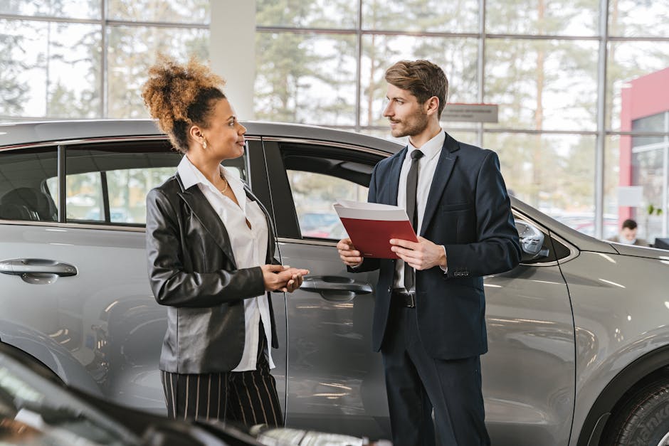 A woman discussing car purchase with a dealer inside a car dealership showroom