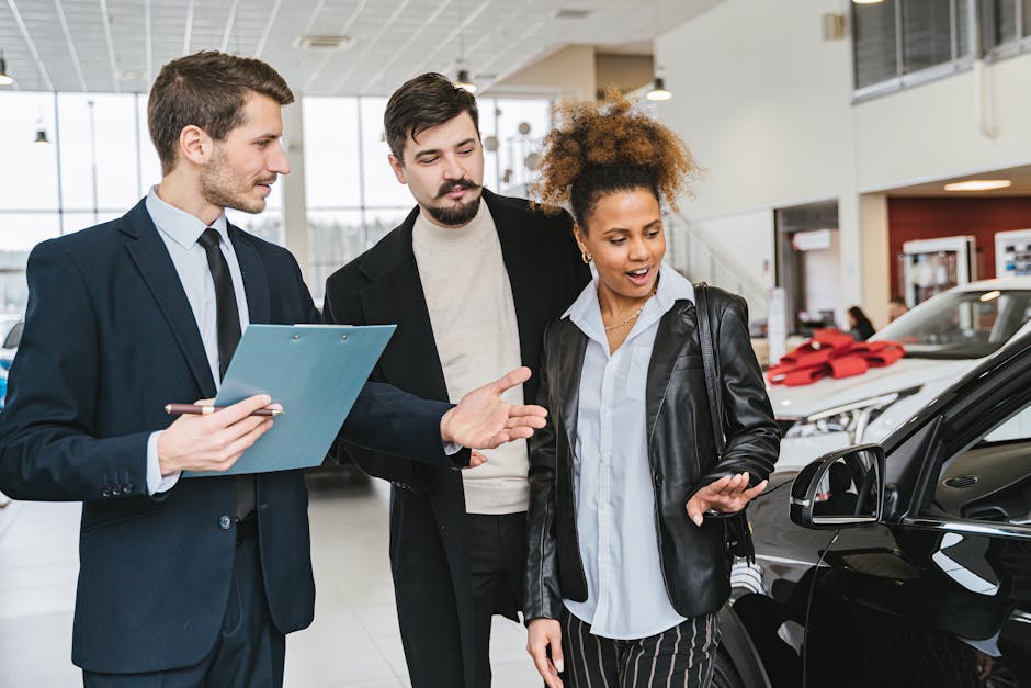 A diverse group of adults discussing vehicles at a bright modern car dealership